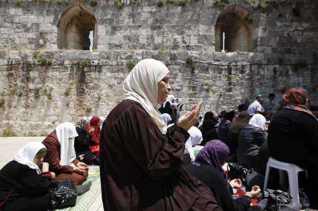 Mulheres palestinas oram próximo à Esplanada das Mesquitas, que abriga a mesquita de Al-Aqsa