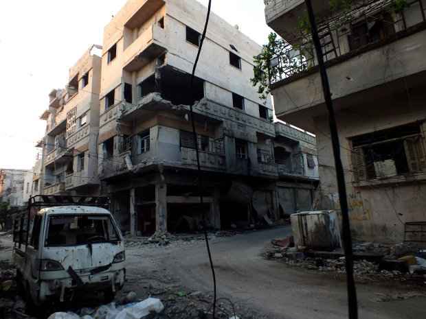 Carro danificado após atentado em rua do distrito de Khaldiyeh no centro de Homs