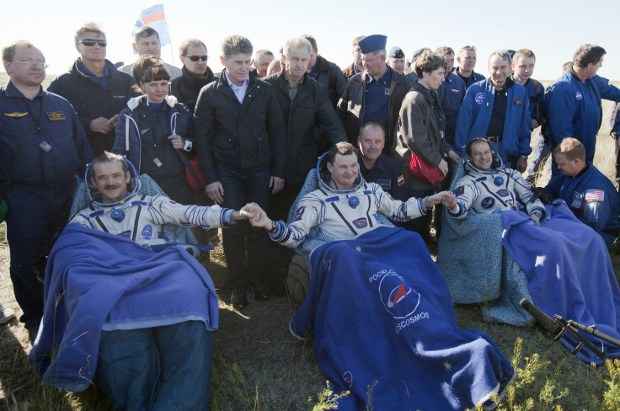 Astronautas após a aterrissagem- (esq- dir) O canadense Chris Hadfield, o russo Roman Romanenko e o americano Tom Marshburn