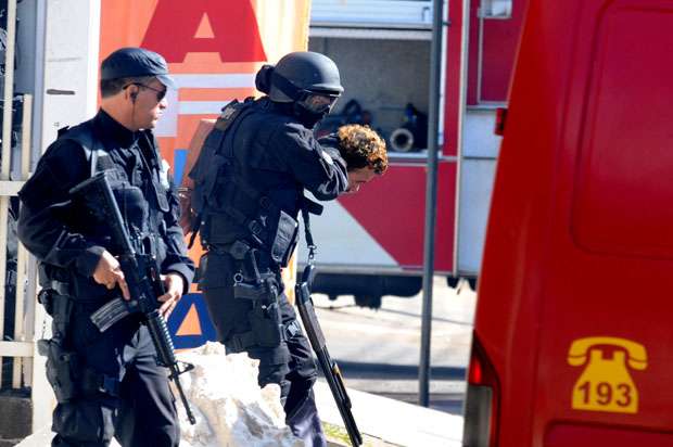 Policiais levam o homem algemado