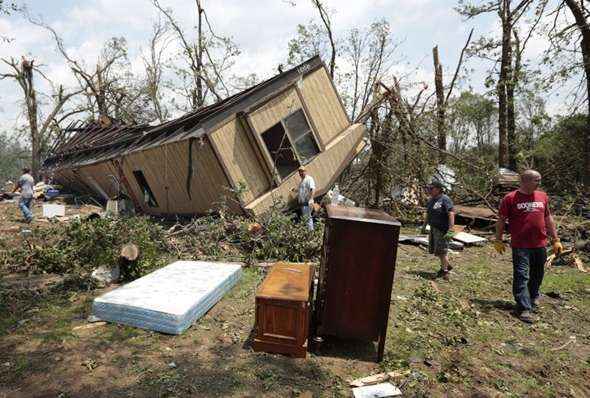 Voluntários ajudam a encontrar sobreviventes em uma região próxima à cidade de Oklahoma devastada por um tornado que deixou dezenas de mortos, incluindo crianças