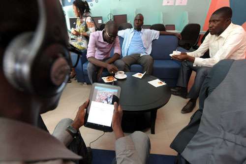 Pessoas navegam na web usando tablets durante a abertura do primeiro tabletcafe do mundo, inaugurado em Dacar, na África