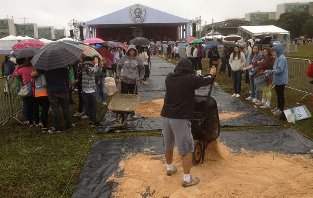 Jovens de todo o DF enfrentam a chuva para compor os desenhos religiosos