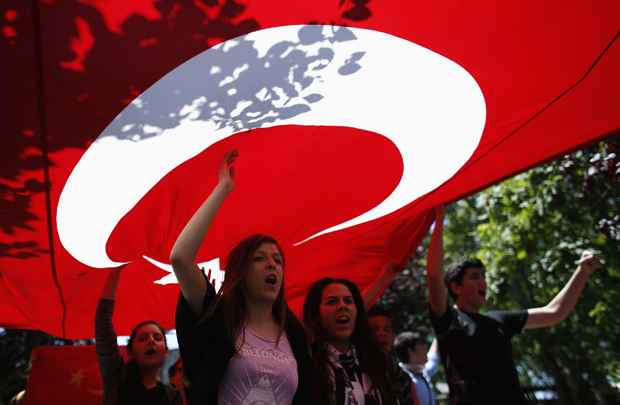 Manifestantes carregam a bandeira turca e gritar slogans anti-governo durante manifestação em Gezi Park, no centro de Istambul