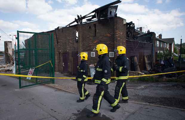 Bombeiros passam pelo Centro Islâmico Al-Rahma que foi danificado pelo fogo, no norte de Londres