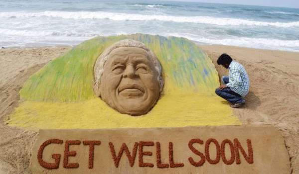 Artista Sudarshan Pattnaik trabalha em uma escultura de areia criado à semelhança do ex-Presidente Sul-Africano Nelson Mandela, para desejar-lhe uma rápida recuperação, em Puri