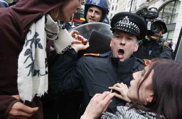 Policiais formam cordão de segurança em briga com ativistas após invadir um prédio usado como base para os manifestantes que protestavam contra a próxima cúpula do G8 no centro de Londres