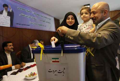 Uma mulher vota com sua família em um posto de votação na embaixada iraniana em Beirute