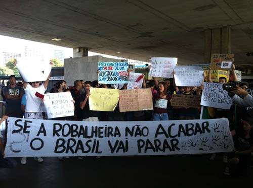 Manifestantes exibem cartazes durante início de protesto