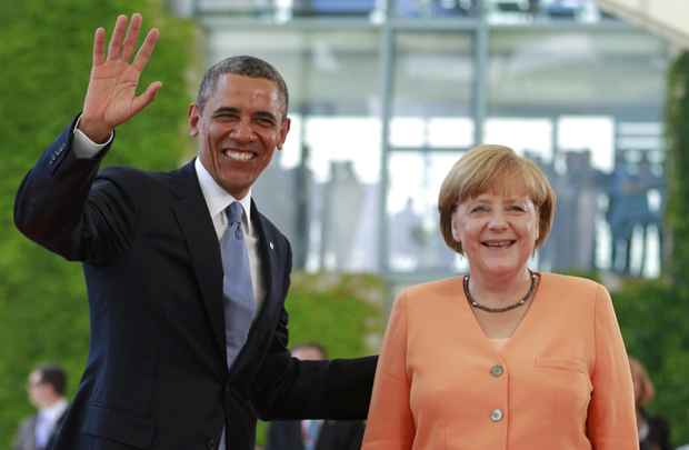 Presidente dos EUA, Barack Obama acena ao lado chanceler alemã Angela Merkel, em Berlim