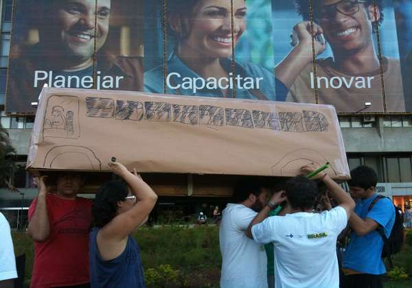 Manifestantes confeccionam ônibus de papelão em frente ao Conic