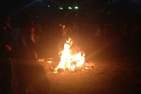 Manifestantes dançam em frente a fogueira feita de cartazes