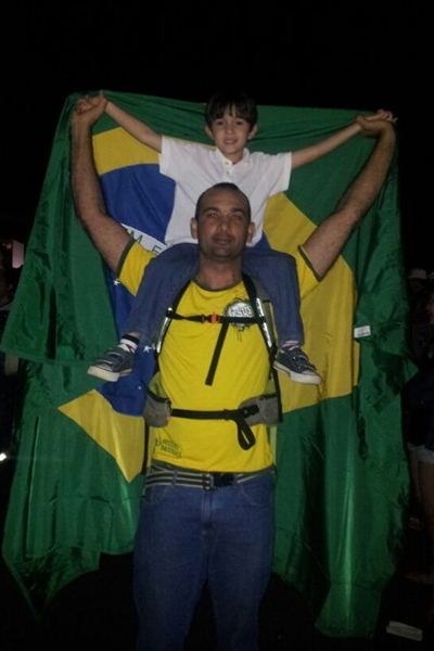 Levi Obalski, de 5 anos, nos ombros do pai e segurando a Bandeira Nacional