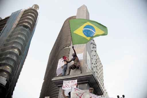 Manifestante com a Bandeira do Brasil, em Belo Horizonte: estudiosos ressaltam que o governo não tem como atender rapidamente as demandas