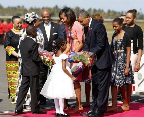 O presidente dos EUA, Barack Obama e a primeira-dama Michelle Obama recebem flores durante a chegada ao aeroporto de Julius Nyerere, em Dar es Salaam, na Tanzânia