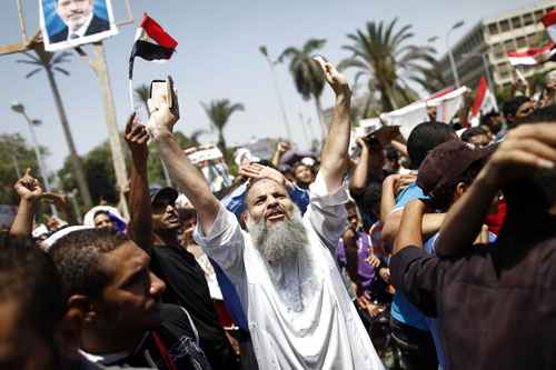 Um defensor egípcio da Irmandade Muçulmana e presidente deposto Mohamed Morsy grita slogans religiosos e políticos durante um protesto perto da Universidade de Cairo na capital egípcia