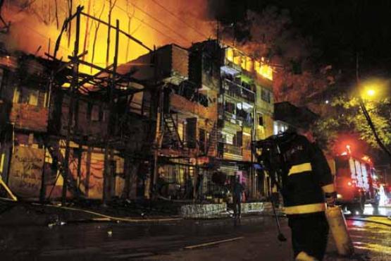 Bombeiro trabalha no combate ao fogo que destruiu centenas de casas e barracos da Comunidade da Ilha