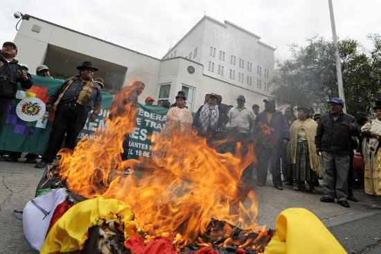 Manifestantes queimam uma efígie do Presidente dos EUA e um caixão com as bandeiras de Espanha, Portugal, a França e Itália durante manifestação no exterior da embaixada dos EUA