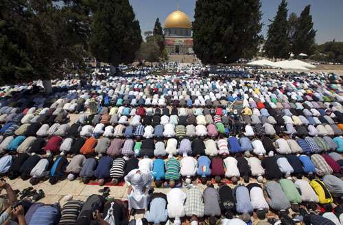 Palestinos oram fora do Domo da Rocha na mesquita Al-Aqsa em Jerusalém durante as orações da primeira sexta-feira do mês de jejum muçulmano do Ramadã o anoitecer