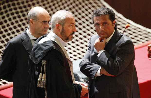 Francesco Schettino (D), o capitão do navio de cruzeiro Costa Concordia, conversa com os advogados durante um julgamento em Grosseto, centro da Itália