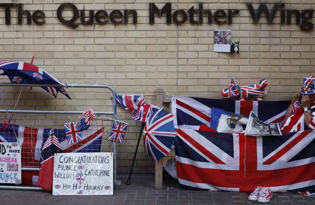 Fã Real lê o jornal do lado de fora do Hospital de Santa Maria, onde Catherine, duquesa de Cambridge está para dar à luz, em Londres