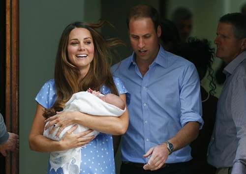 Kate, de vestido azul com bolas brancas, e o Príncipe William, de camisa azul claro, exibiram o seu filho para centenas de jornalistas do mundo inteiro