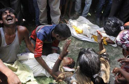 Foto de arquivo mostra familiares lamentando os corpos das crianças que morreram envenenadas com a comida oferecida na escola