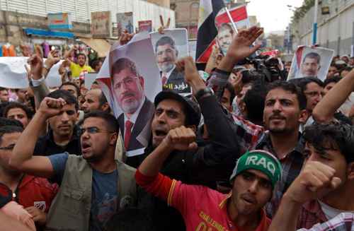 Partidários do presidente deposto do Egito, Mohamed Morsy (retrato) em manifestação em Sanaa