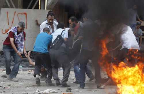 Partidários de Morsy carregam manifestante ferido durante confrontos no Cairo