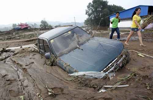 Carro fica encalhado na lama após fortes chuvas que atingiu Fushun, província de Liaoning, na China