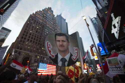 Ativistas locais e apoiadores do presidente sírio, Bashar al-Assad, manifestam contra um ataque militar na Síria, em frente a uma estação de recrutamento das Forças Armadas dos EUA na Times Square, em Nova York