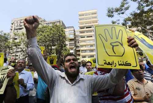 Os membros da Irmandade Muçulmana e simpatizantes do deposto presidente egípcio, Mohamed Morsy gritam contra os militares e o Ministério do Interior, durante uma marcha de protesto para Mohandessin no Cairo