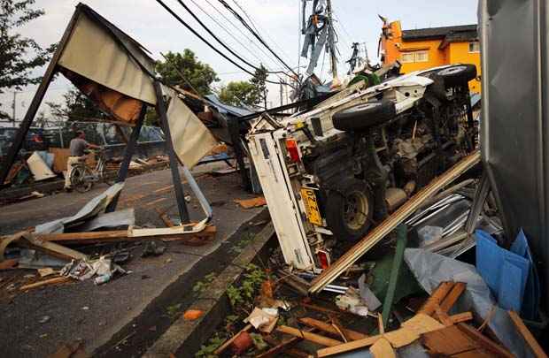 Carro capotado e casas danificadas por tornado em Koshigaya, ao norte de Tóquio. Várias pessoas foram hospitalizadas após fenômeno que destruiu em uma hora as cidades de Koshigaya e Noda. Milhares de casas ficaram sem energia.