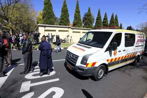 Membros da polícia sul-africana montam guarda perto de uma ambulância que estava escoltando Nelson Mandela