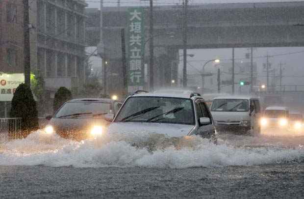 Carros passa por estrada inundada de Nagoya, na província de Aichi