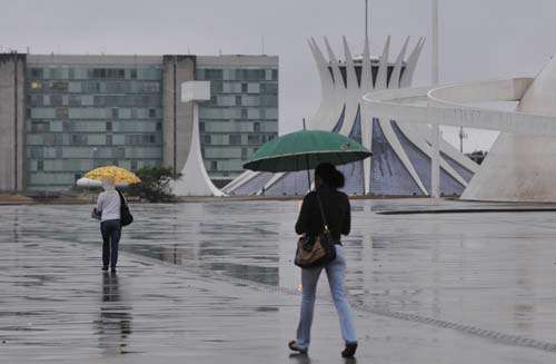 Brasilienses caminham sob chuva próximo à Catedral