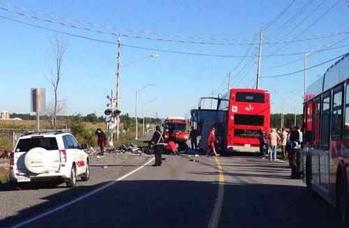 Curiosos olham acidente entre ônibus de dois andares e trem em Ottawa