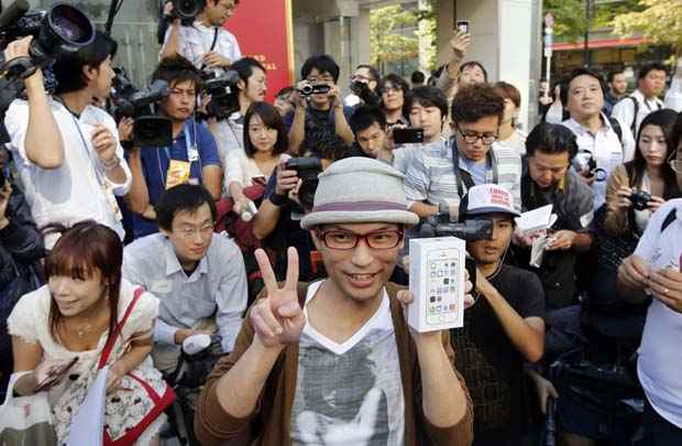 Homem posa com caixa do novo iPhone 5S depois de esperar na fila 10 de setembro pelo novo aparelho da Apple, em Ginza, Tóquio