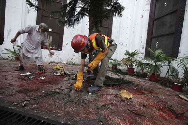 Equipe de resgate colhe provas no local da explosão em uma igreja em Peshawar