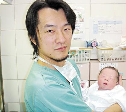 O médico Kazuhiro Kawamura, um dos integrantes da pesquisa, com o bebê nascido pela técnica