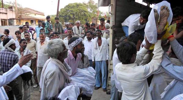 Indianos carregam corpos de vítimas de confusão perto de um templo do distrito de Datia, no estado de Madhya Pradesh