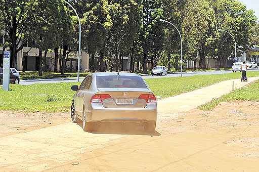 Na 207 Norte, carros passam constantemente sobre a pista para bikes com o intuito de acessar um estacionamento: concreto já está danificado