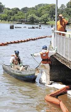 Técnicos da Petrobras ficam atentos ao trabalho de contenção do óleo que se espalhou pelo lago há 10 dias