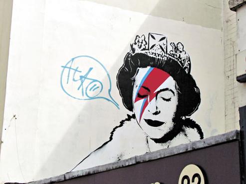 O artista Banksy fez um grafite com referência aos 60 anos de reinado da rainha Elizabeth II e aproveitou para saudar o álbum Alladin Sane, de David Bowe: homenagens misturadas