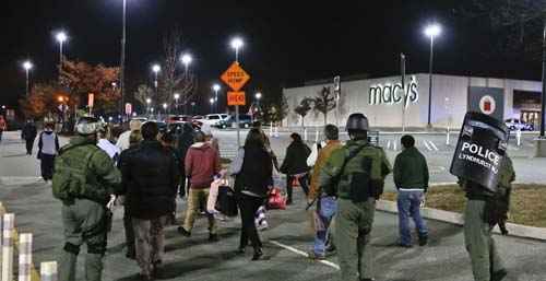 Policiais escoltam um grupo de trabalhadores e clientes do Garden State Plaza shopping depois de um bloqueio para baixo durante a resposta da polícia aos relatos de que um homem armado havia disparados tiros no shopping, em Paramus, New Jersey