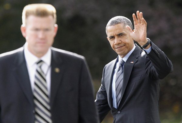 Presidente dos EUA, Barack Obama acena enquanto caminha no gramado sul da Casa Branca, em Washington