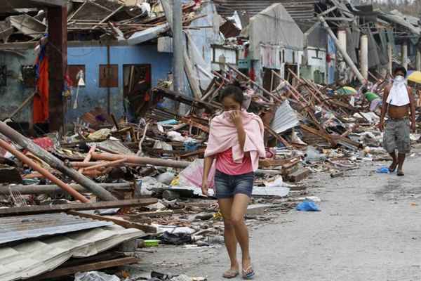 Moradores de Tacloban, arrasada pelos ventos e pelas ondas, fazem fila para recolher donativos no aeroporto da cidade, transformado em abrigo