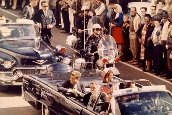 John Kennedy desfila em carro aberto pelas ruas de Dallas, no Texas, ao lado da primeira-dama, Jacqueline: poucos minutos depois, um tiro de fuzil atingiria a cabeça do presidente
