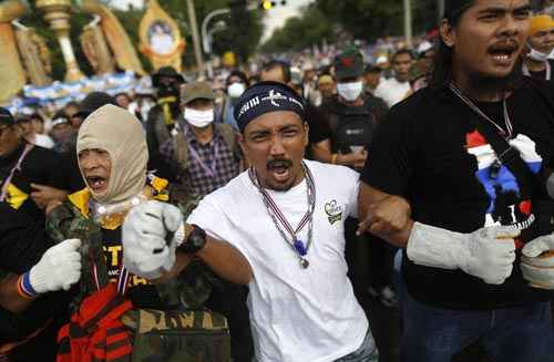 Manifestantes da oposição se preparam para atacar uma barricada policial perto da casa do governo, em Bangcoc