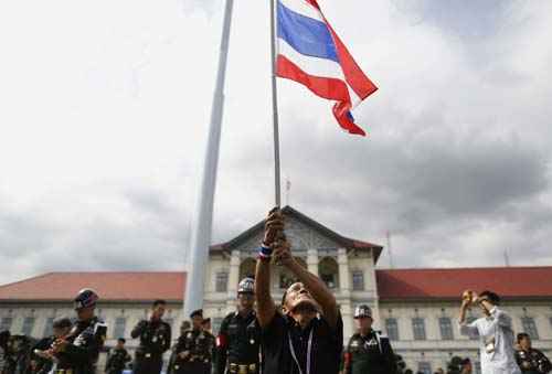 Manifestante seguram bandeira nacional depois de invadir o composto da  do exército da Tailândia